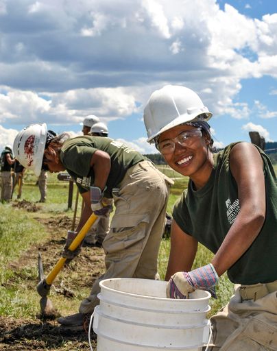 A mile high youth corps member works on a planting project