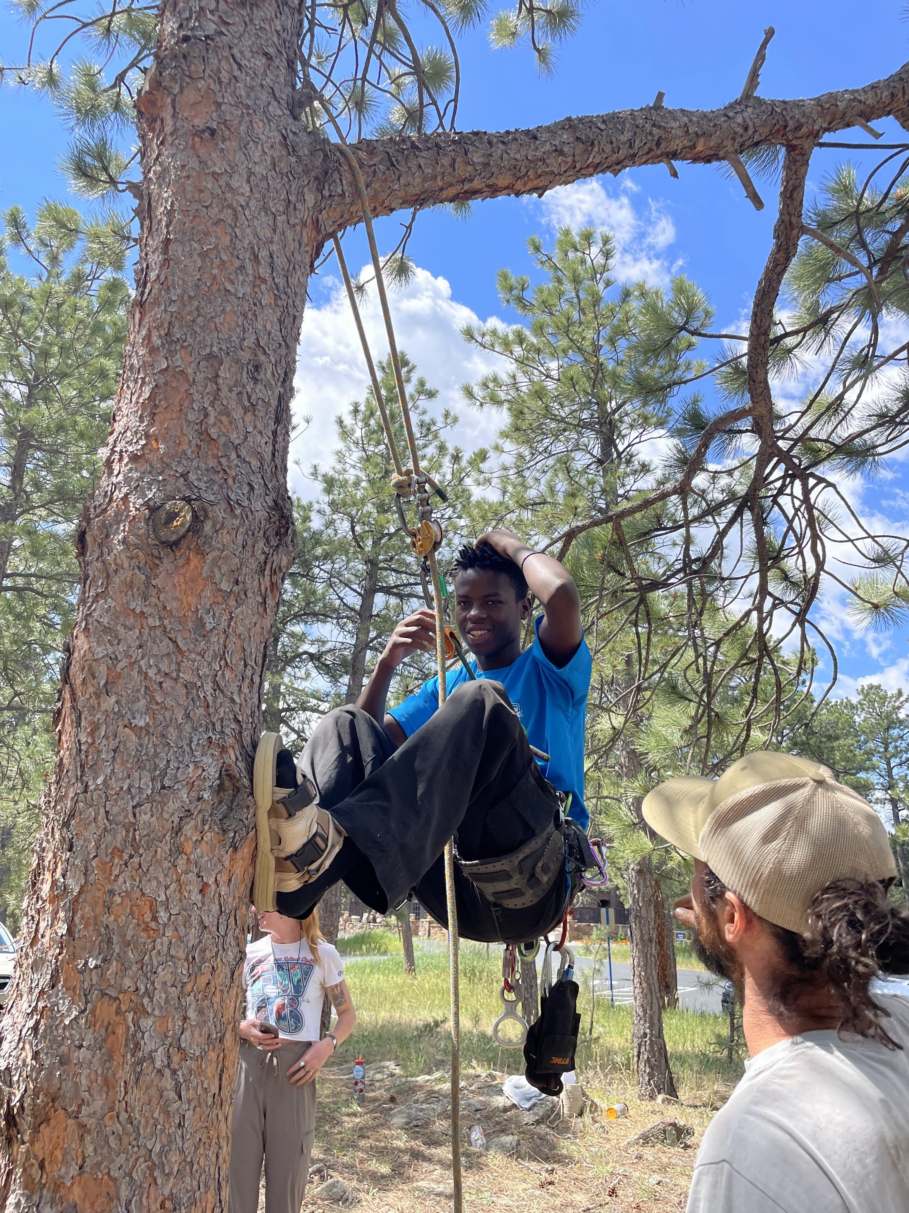 Crew Member at Education Day in an Arborist workshop being repelled from a tree. 