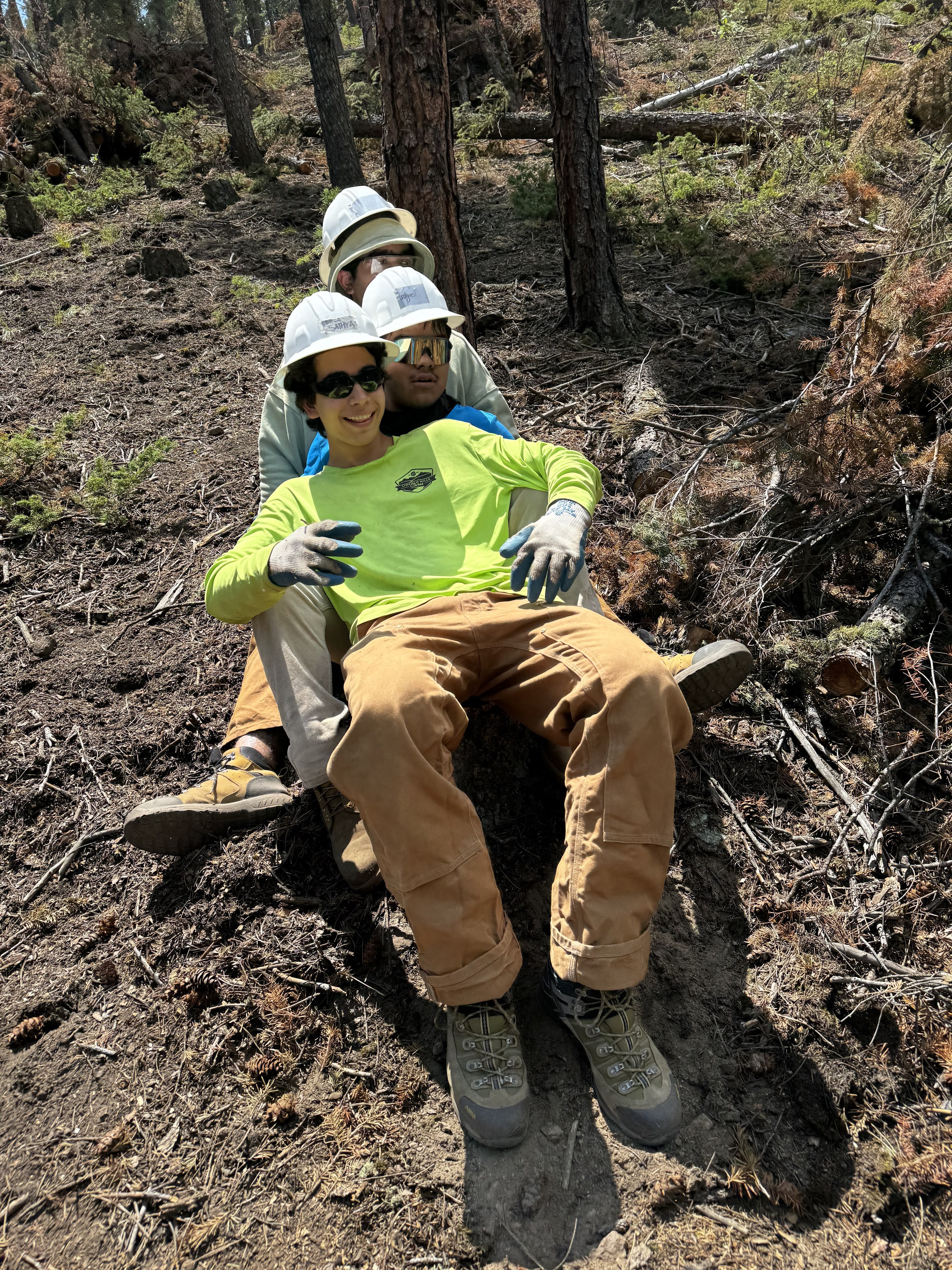 Crew members sitting in a line smiling and hanging out together.