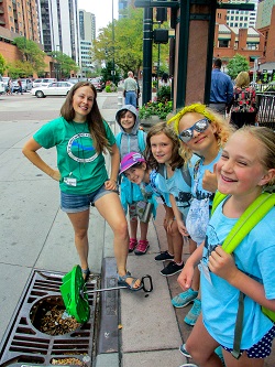 Lauren Berent discusses stormwater pollution with students at a storm water drain