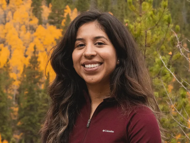 Isis Rivera Lopex headshot in front of fall Colorado foliage