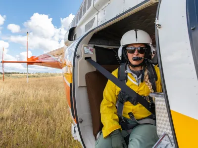 A women firefighter sits in a helicopter