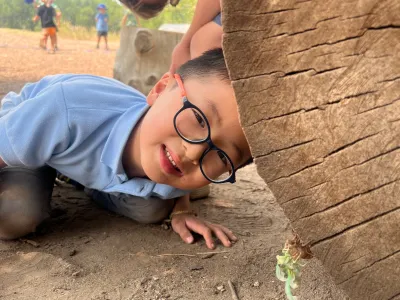 Two children play on a log.
