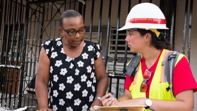Two environmental engineers with the U.S. Army Corps of Engineers discuss paperwork at a construction site