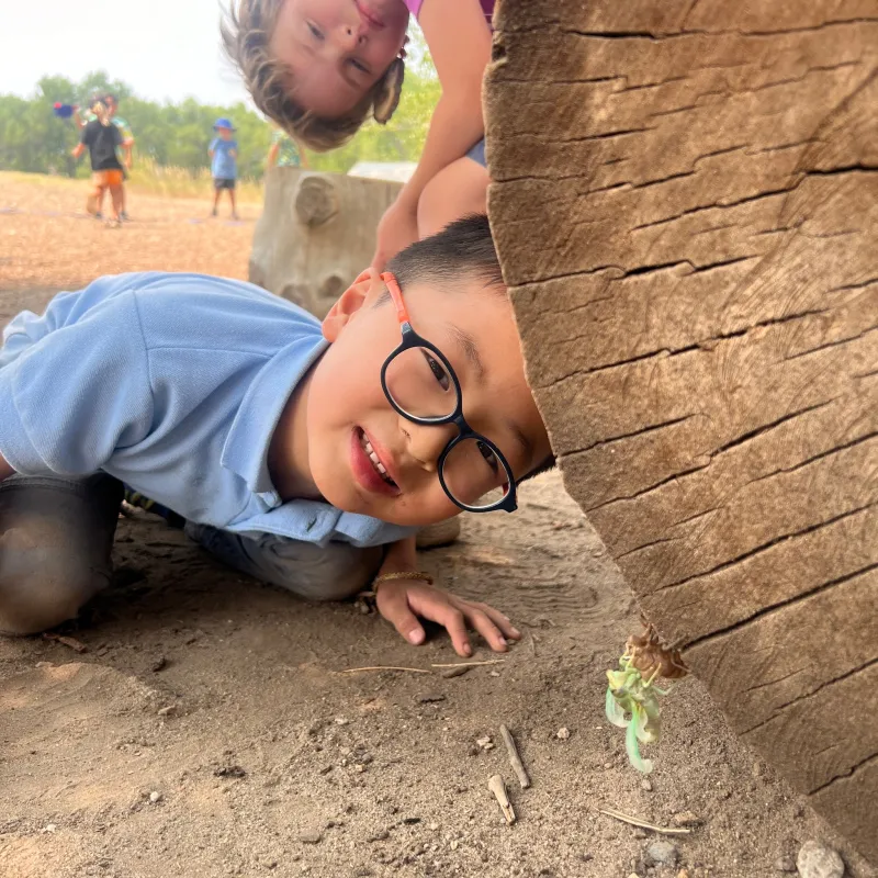 Two children play on a log.