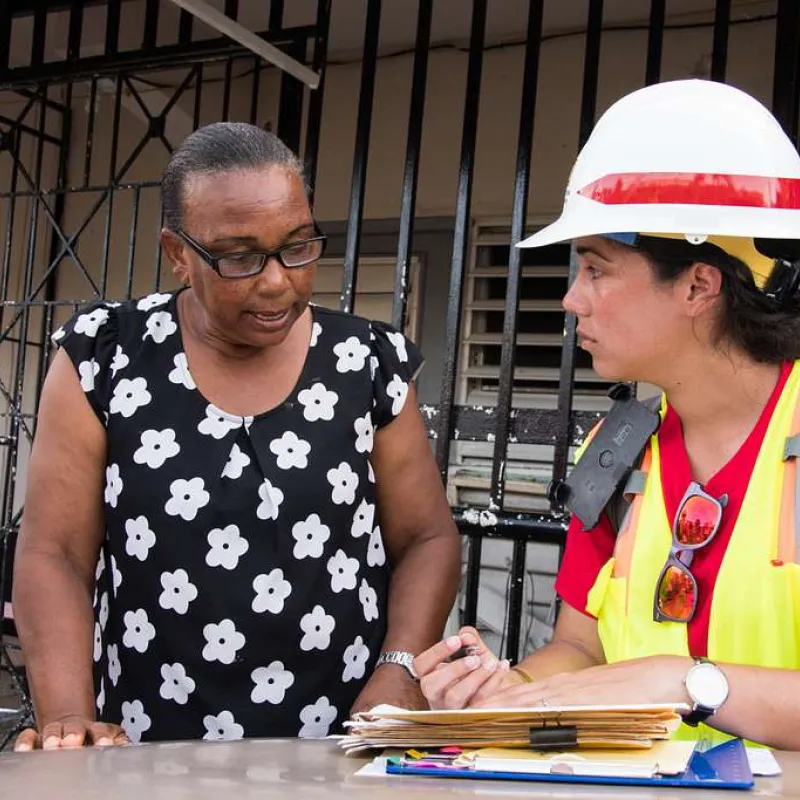 Two environmental engineers with the U.S. Army Corps of Engineers discuss paperwork at a construction site