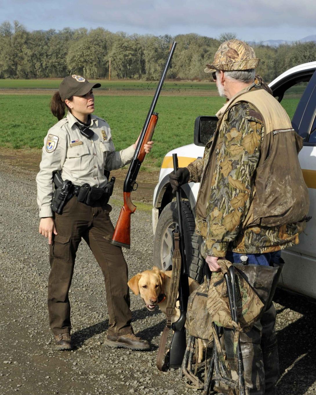 A conservation law enforcement officer talks with a hunter