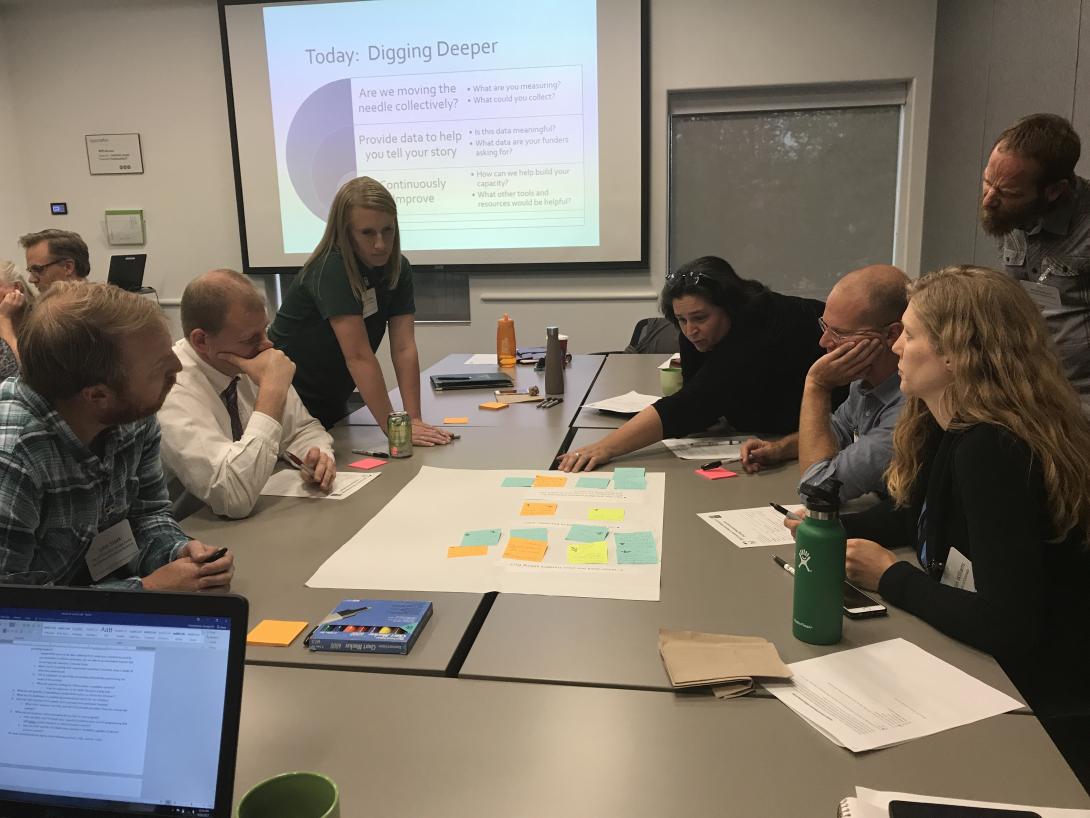 Community members gather around a table to discuss a plan.